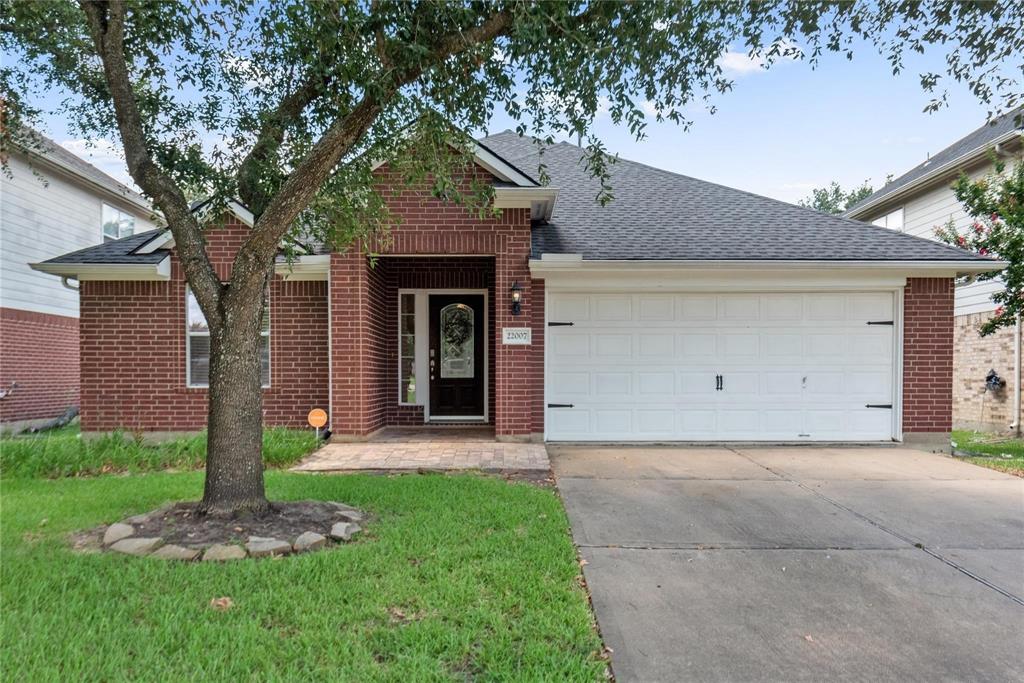 a view of a house with a yard and tree