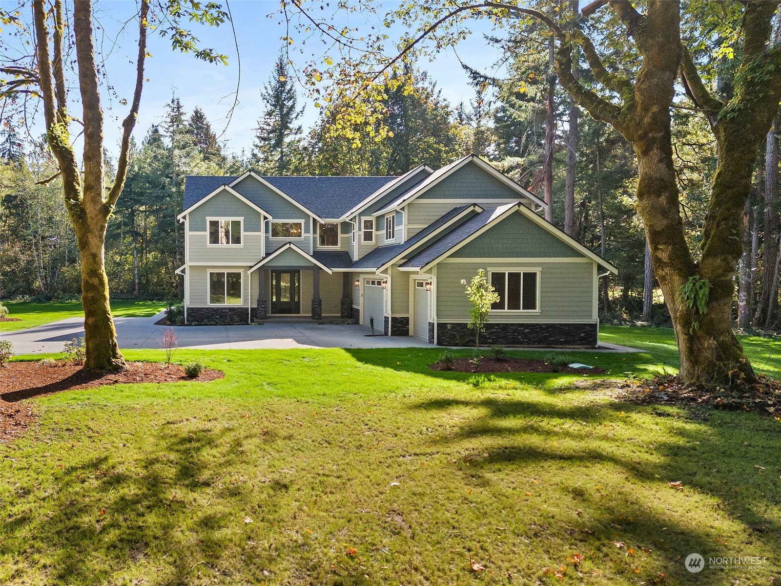 a front view of a house with yard and green space