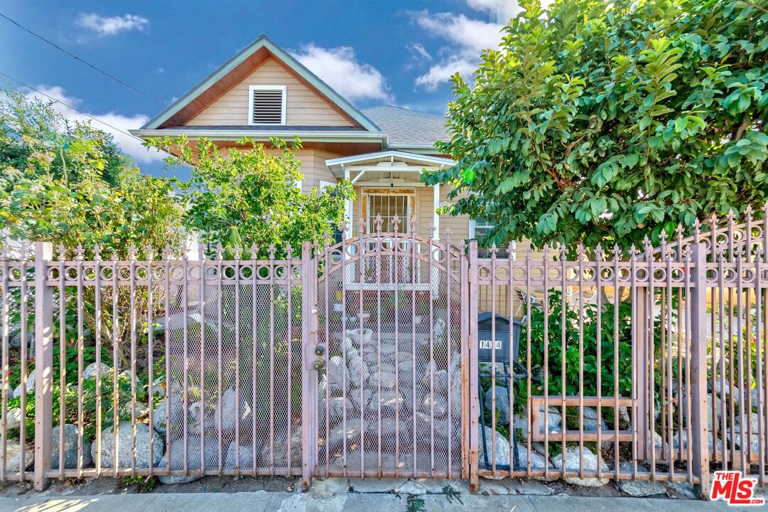 a front view of a house with a small yard and plants