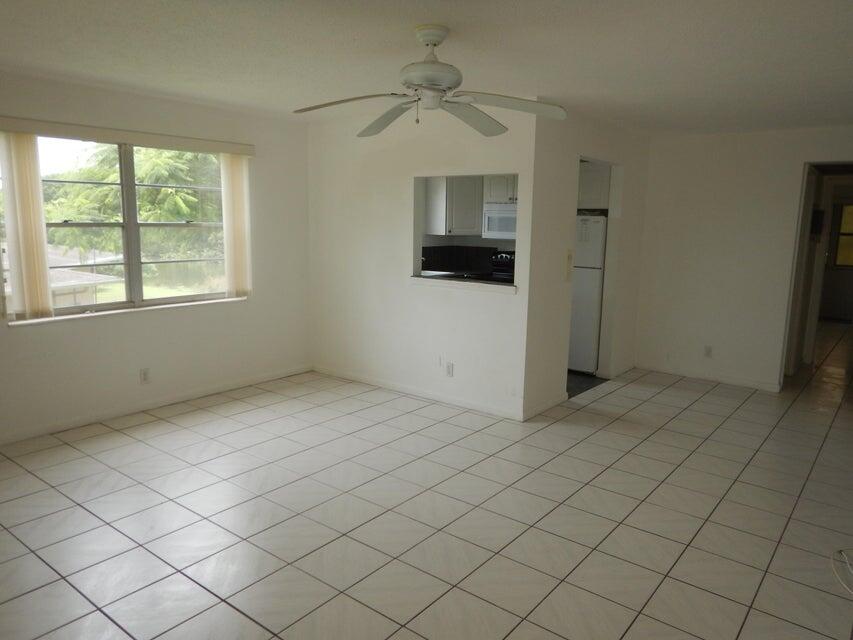 an empty room with a ceiling fan and window