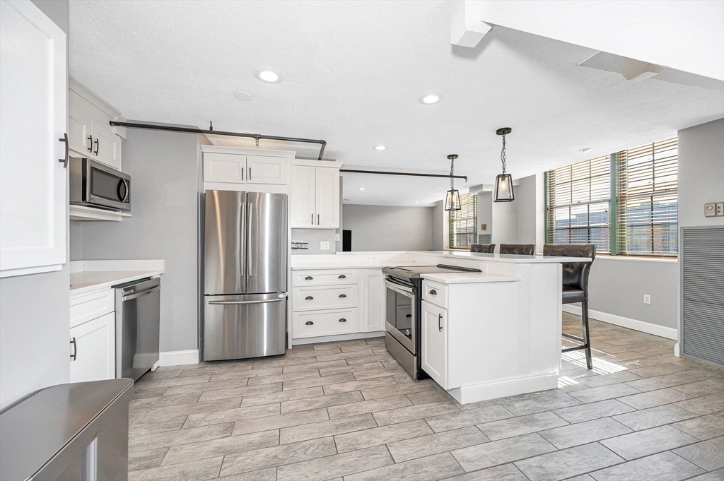 a kitchen with white cabinets and stainless steel appliances