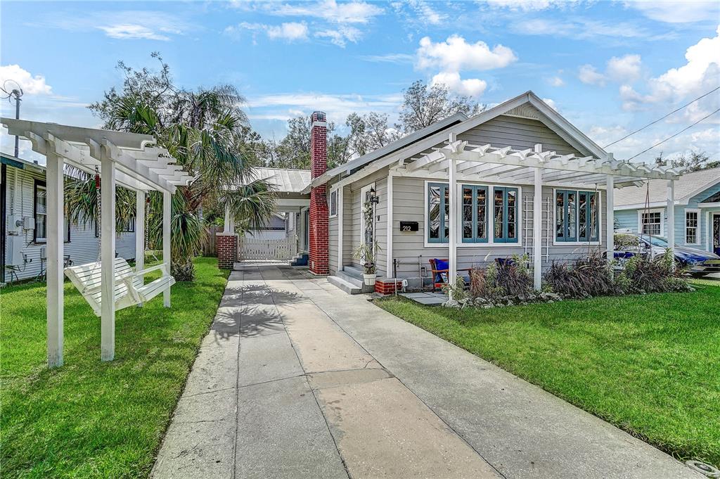 a front view of a house with a yard and potted plants