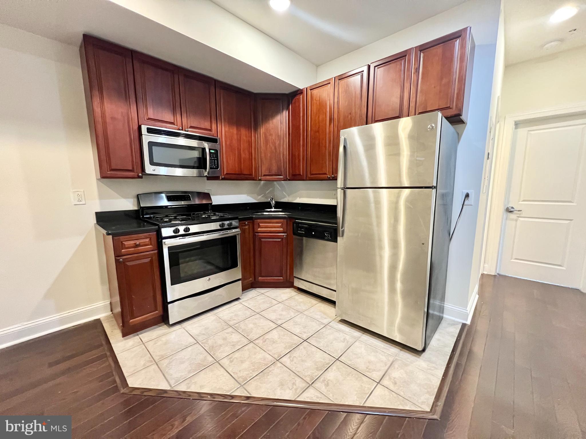 a kitchen with a refrigerator a stove top oven a refrigerator and cabinets