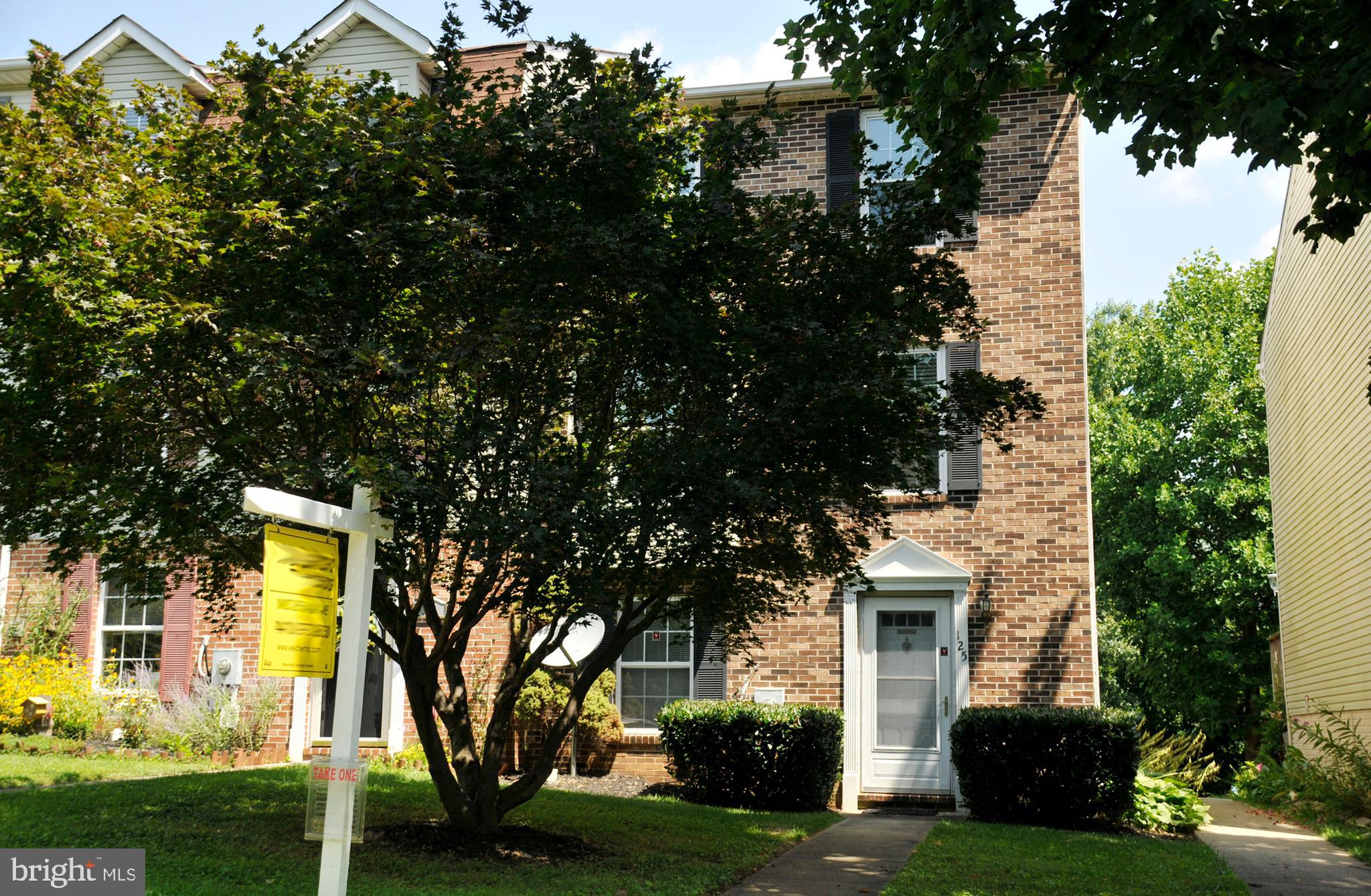 a front view of a house with yard and green space