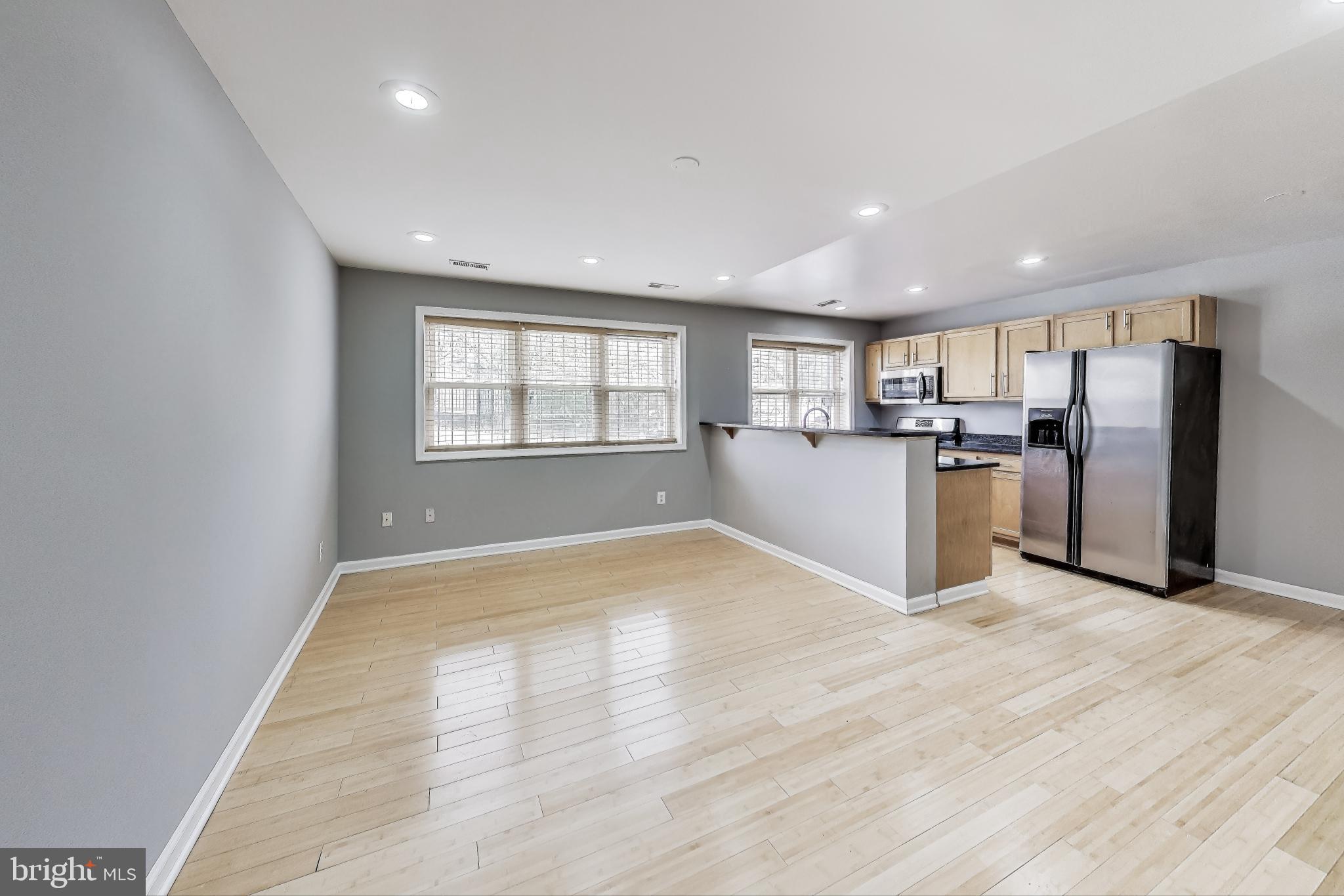 a view of a kitchen with a sink refrigerator and a window