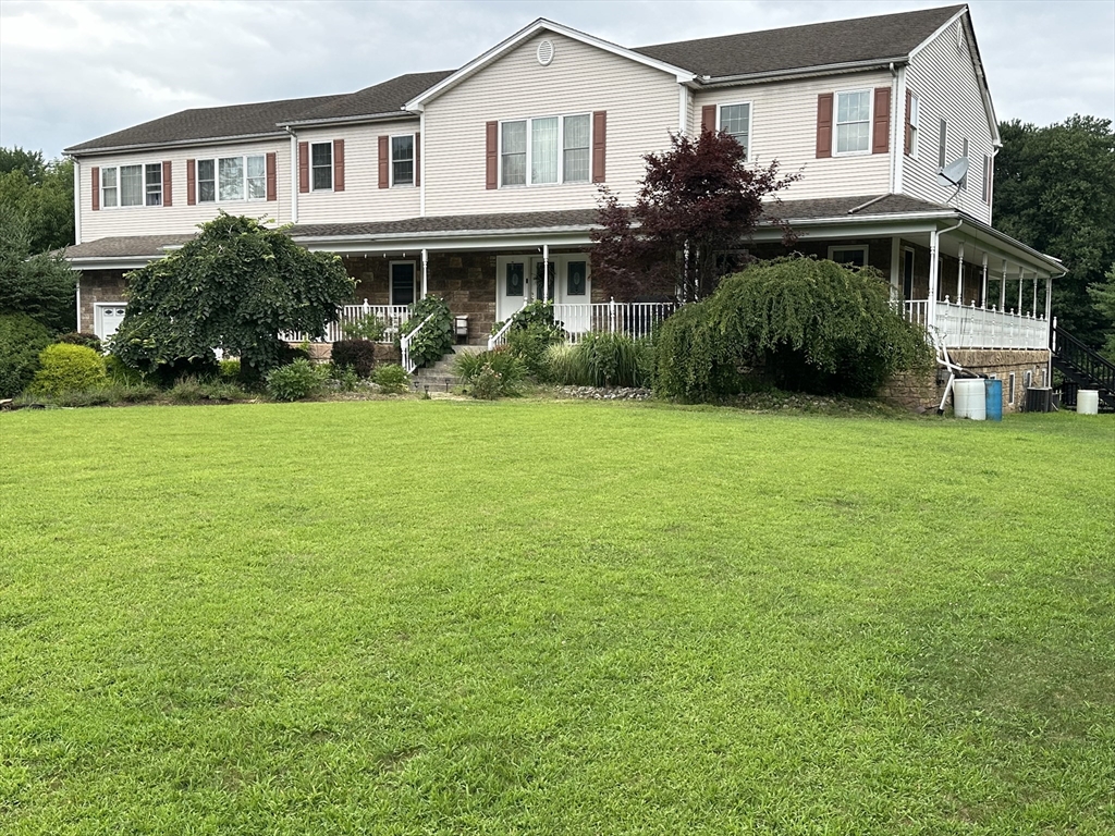 a front view of a house with a garden