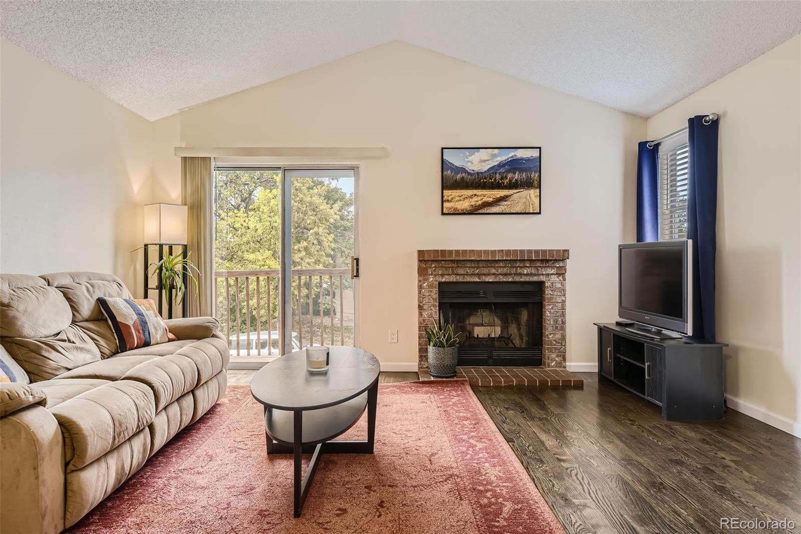 a living room with furniture a large window and a fireplace