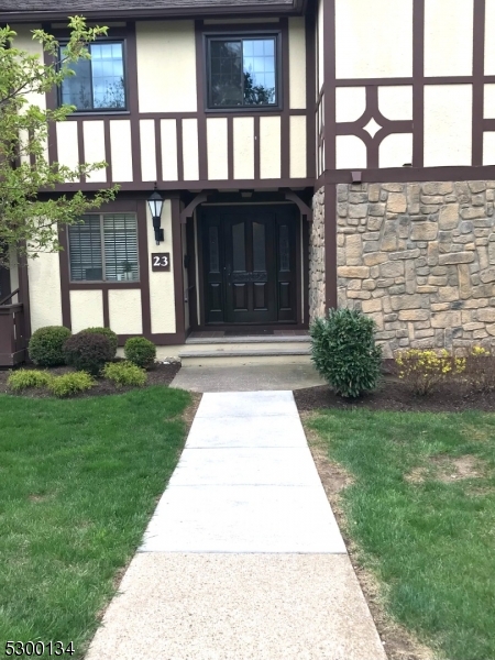 a front view of a house with a yard and potted plants