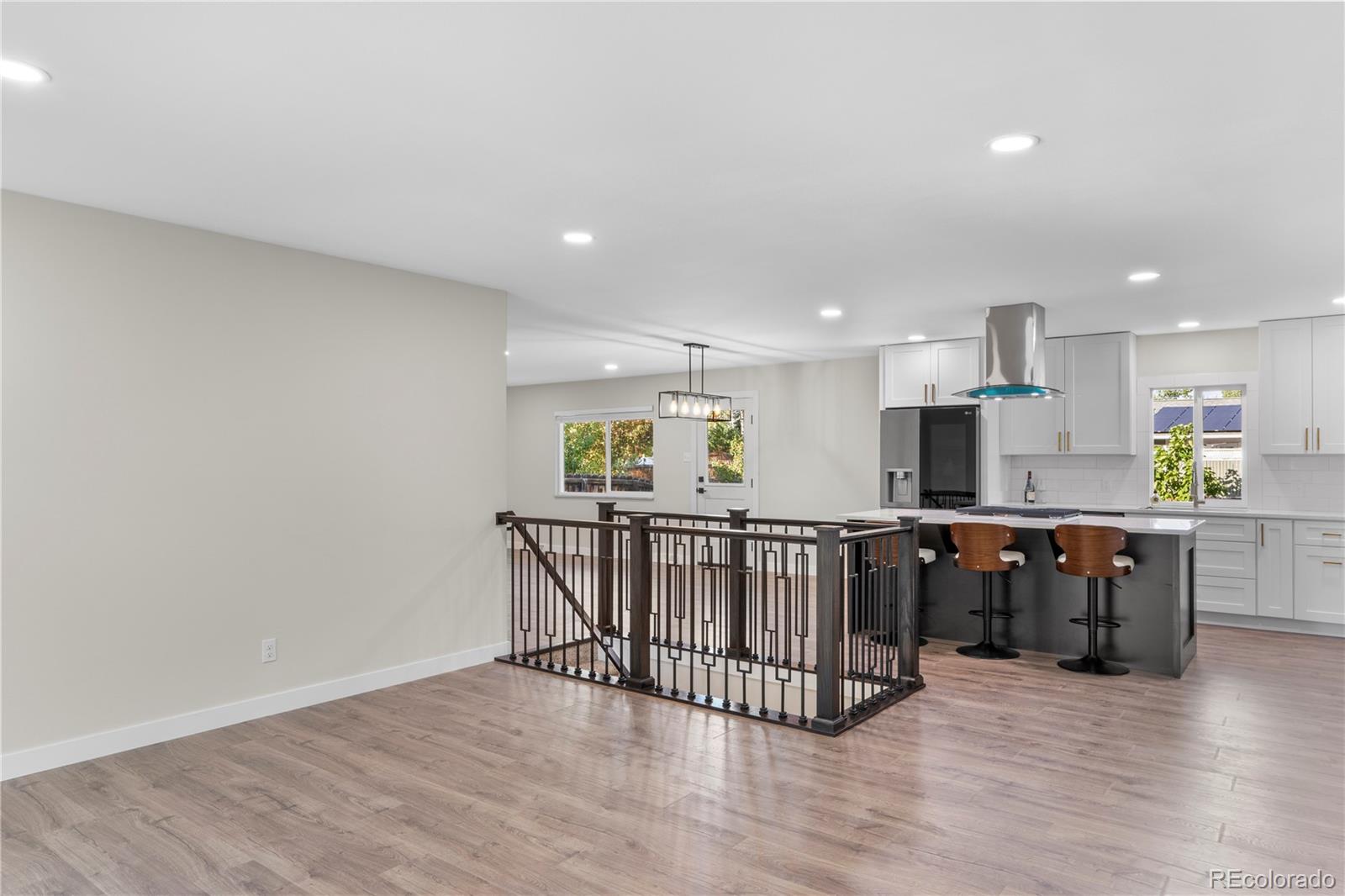 a view of kitchen with stainless steel appliances granite countertop a stove top oven a sink and dishwasher with wooden floor