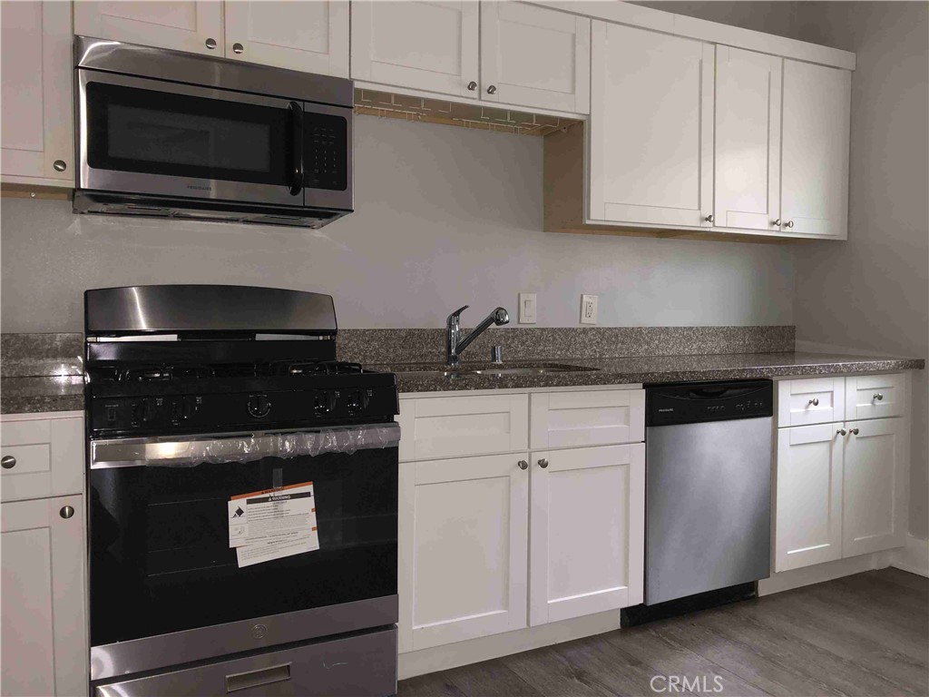 a kitchen with stainless steel appliances granite countertop a stove and a microwave