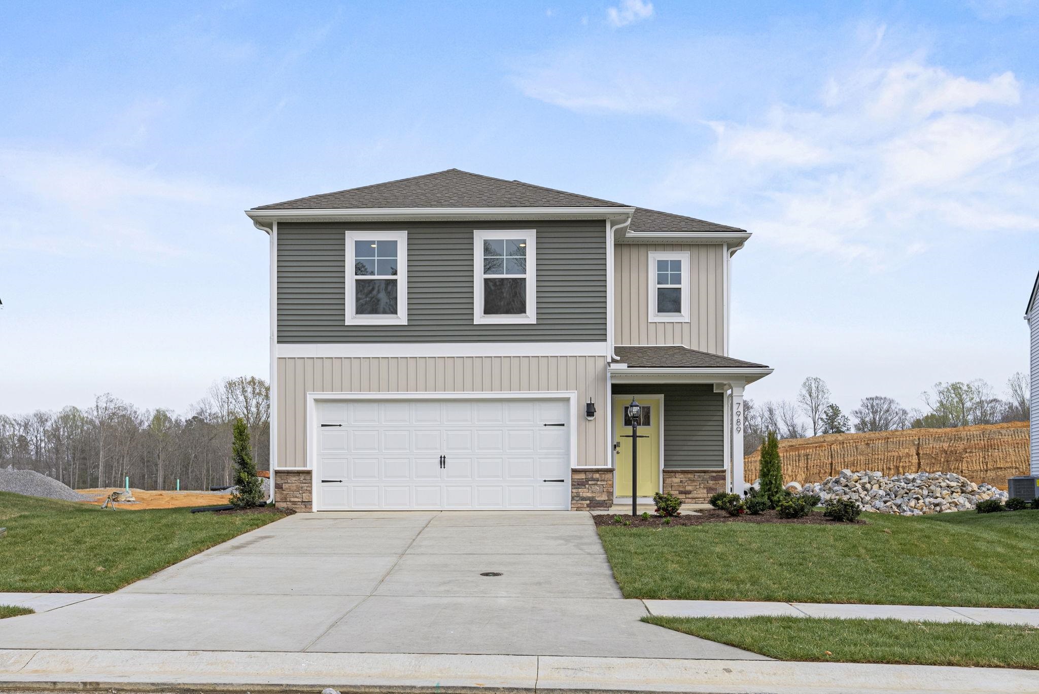 a front view of a house with a yard and garage