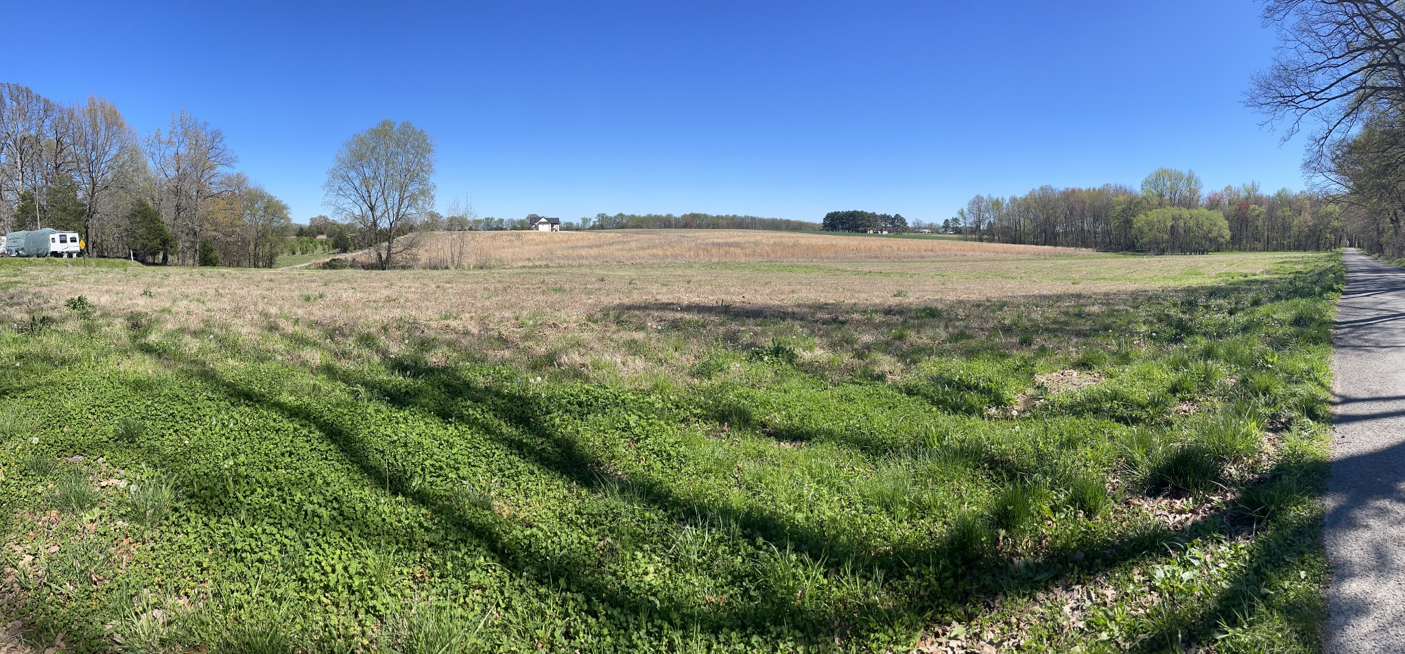 a view of a large yard with lots of green space and house in the background