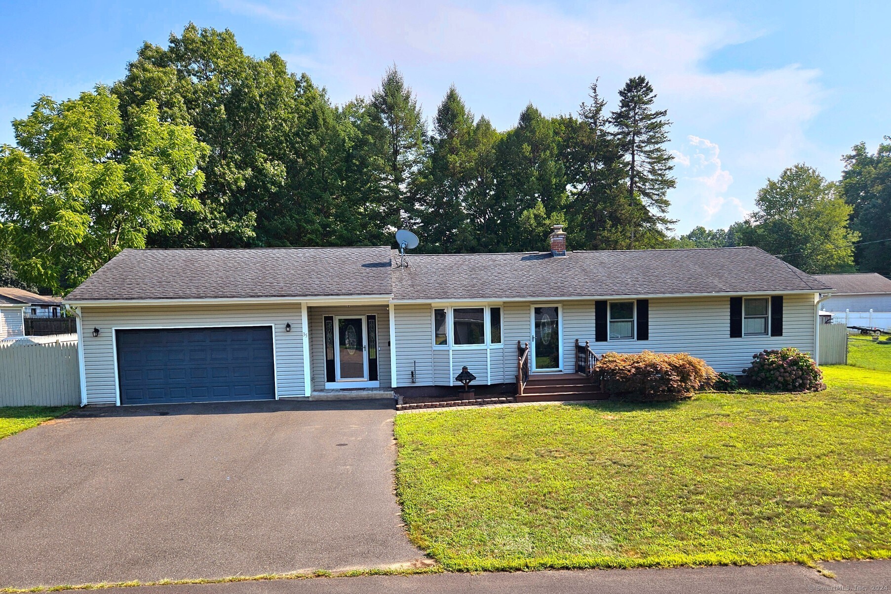 a front view of a house with yard patio and green space