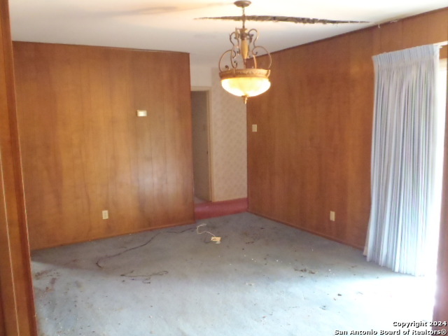 a view of a room with a chandelier fan and a window