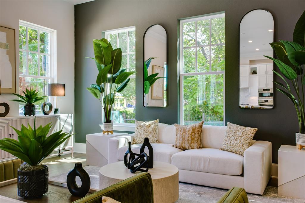 a living room with furniture a potted plant and a large window