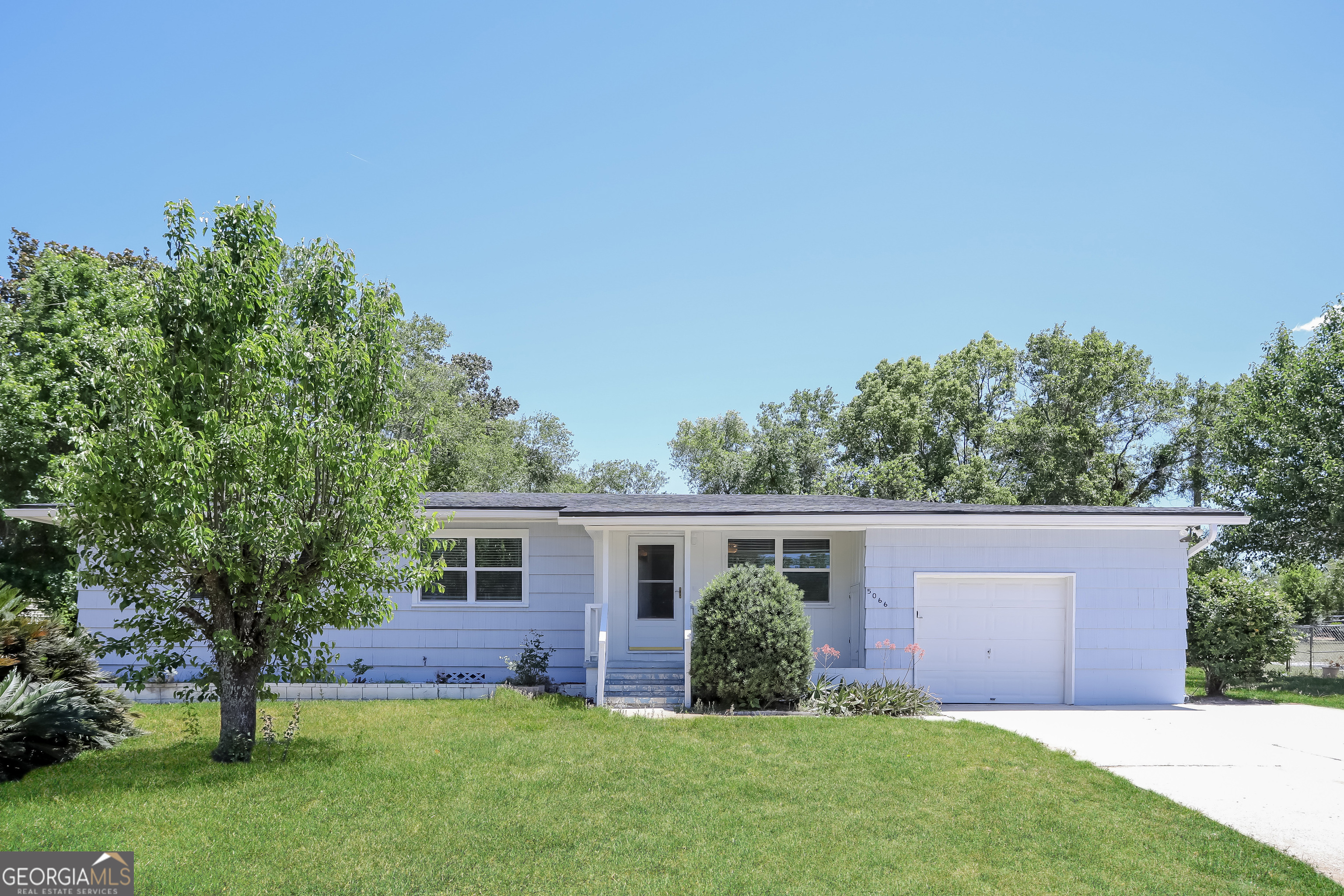 a view of backyard of house with green space