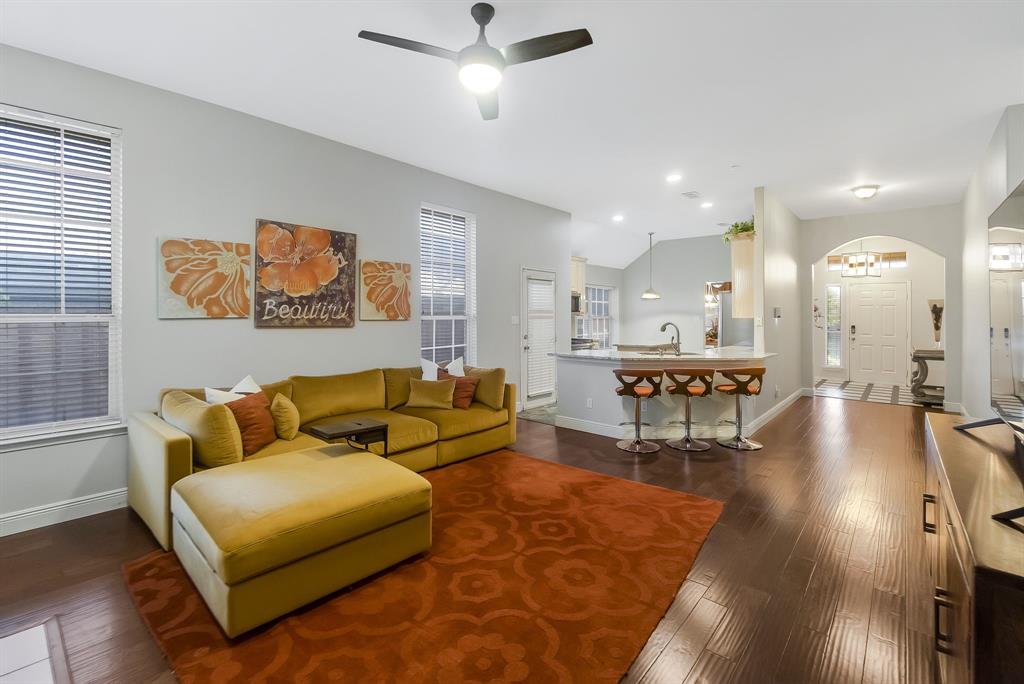 a living room with furniture and a wooden floor