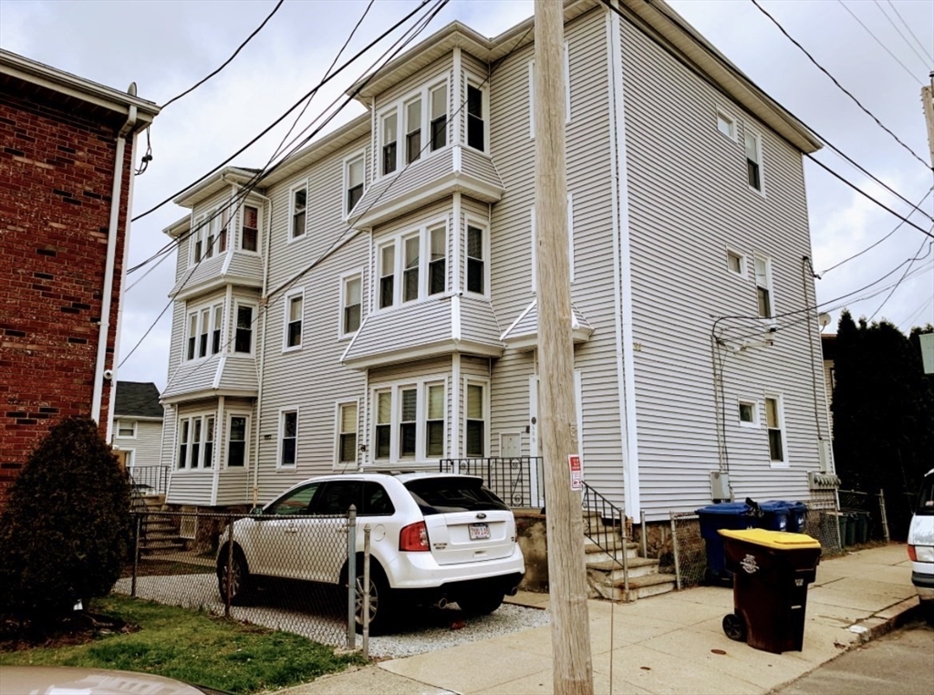 a couple of cars parked in front of a house