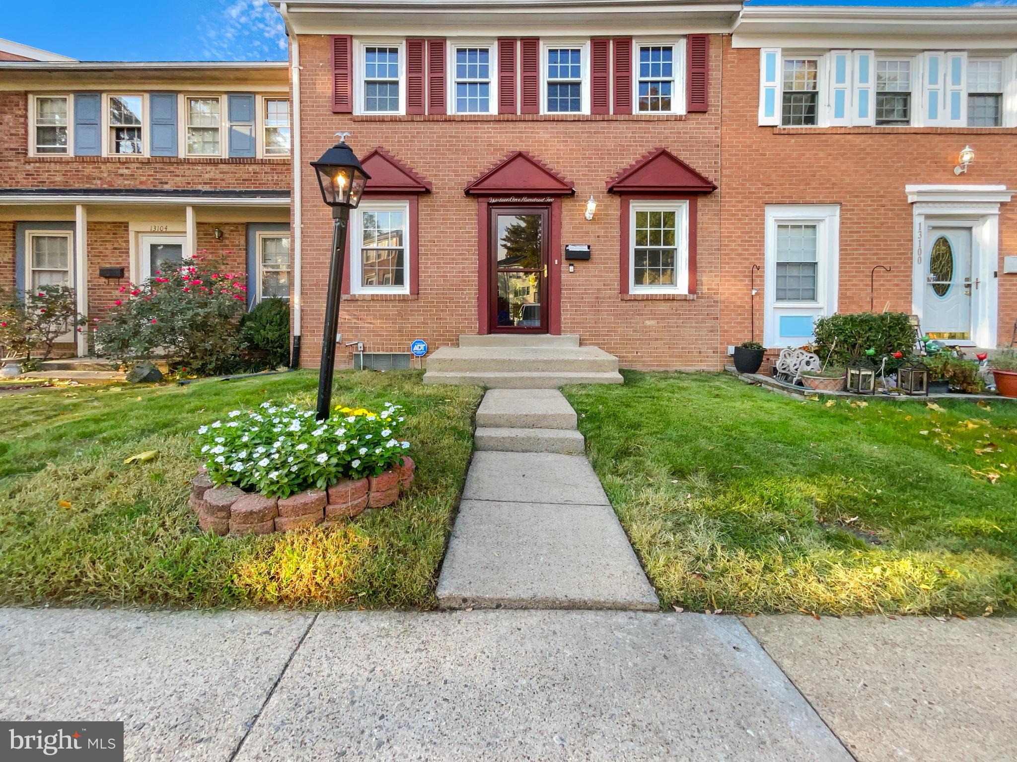 front view of a brick house with a yard