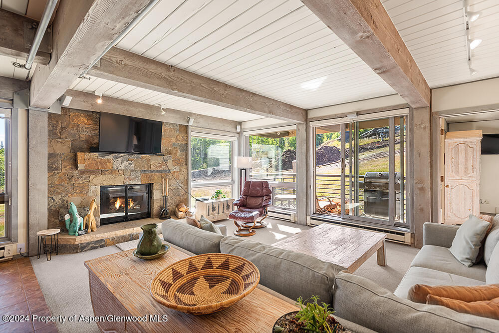 a living room with furniture fireplace and a large window