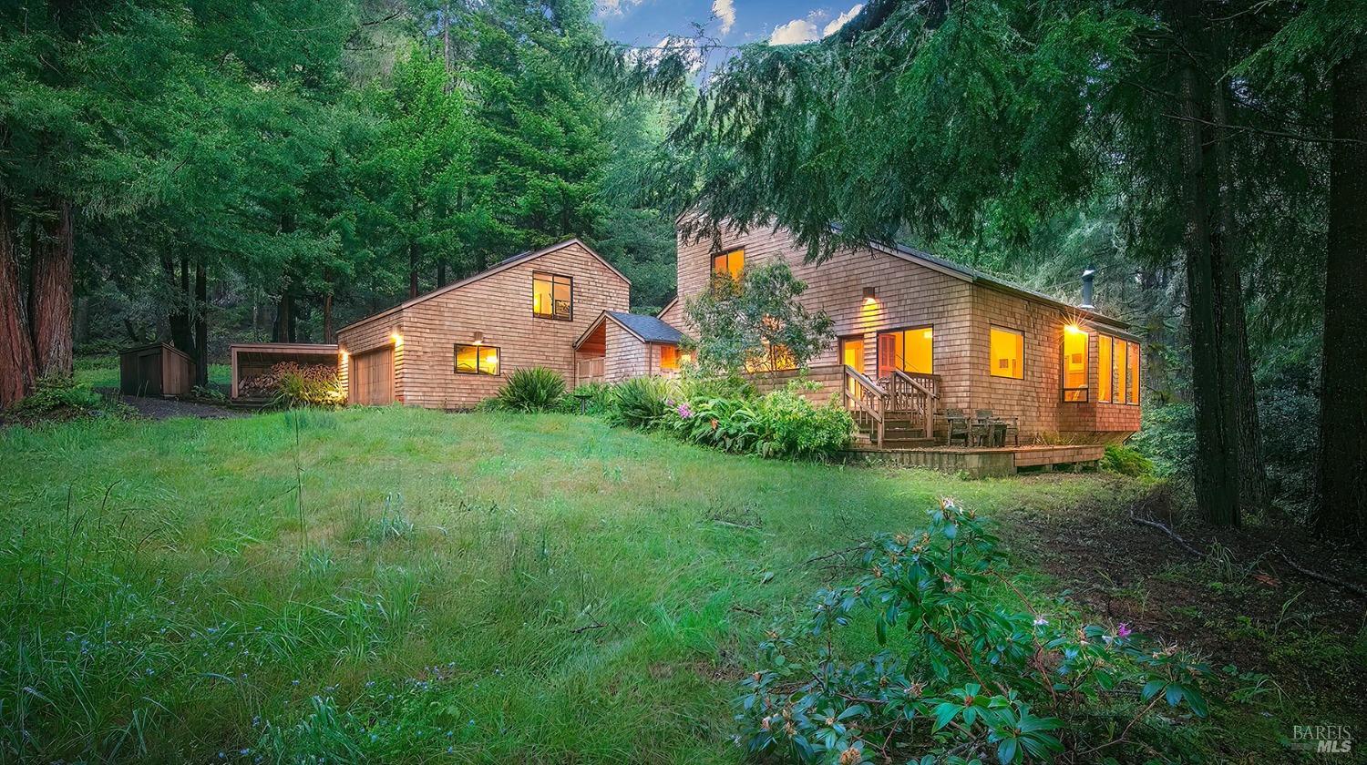 a view of a big house with a big yard and large trees