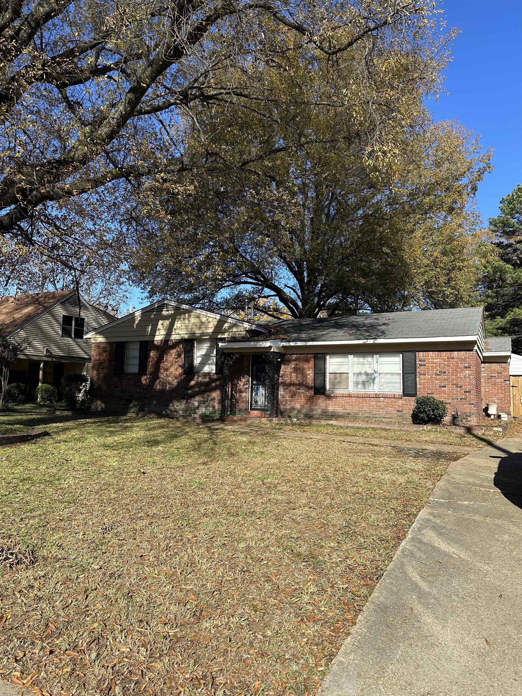 a front view of a house with a garden and trees