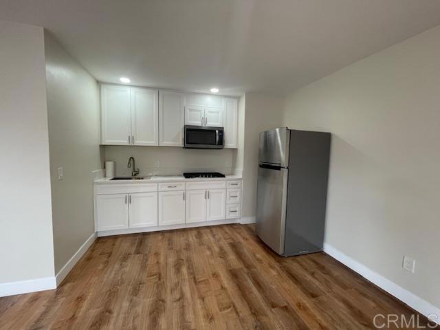 a kitchen with granite countertop white cabinets and stainless steel appliances