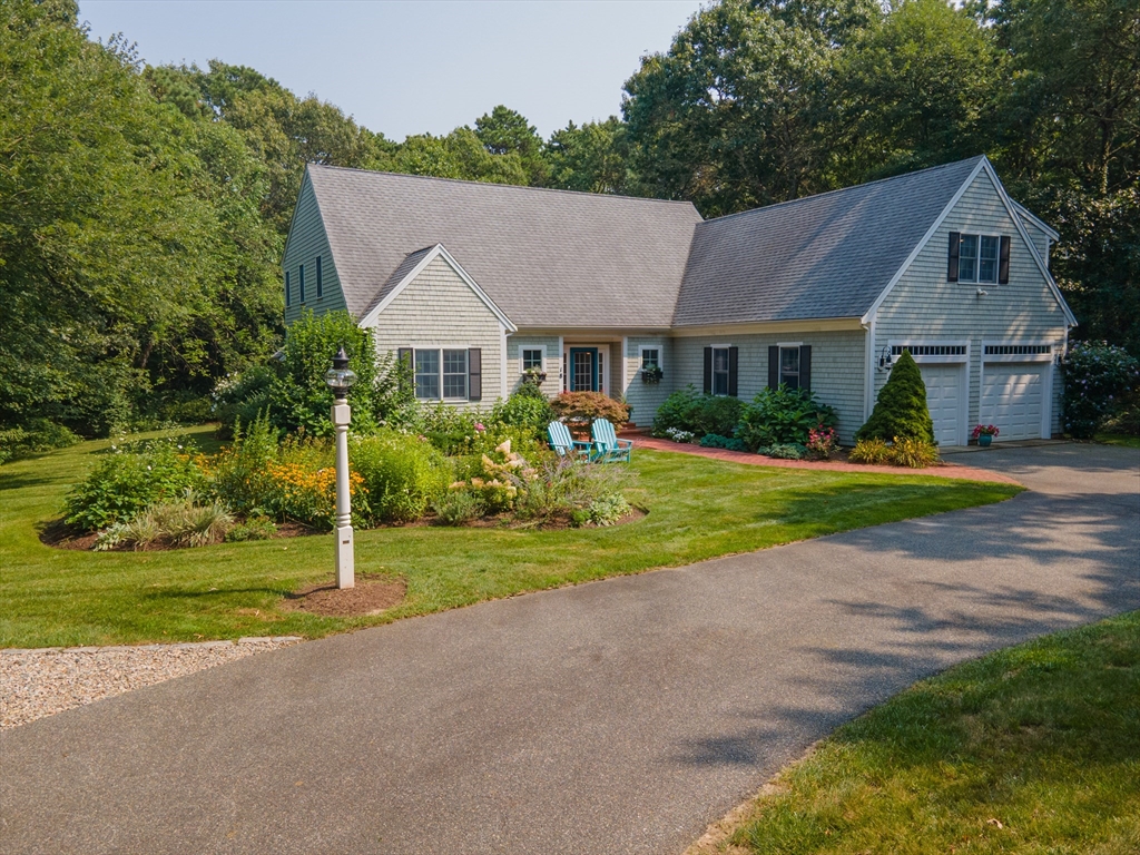 a view of house in front of a big yard with potted plants