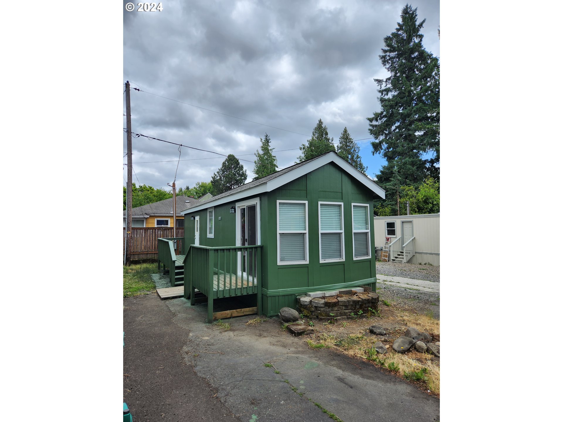 a view of a small house with a yard a table and chairs