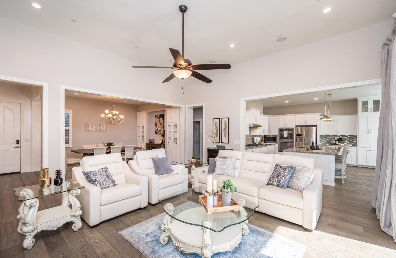 a living room with furniture kitchen view and a chandelier