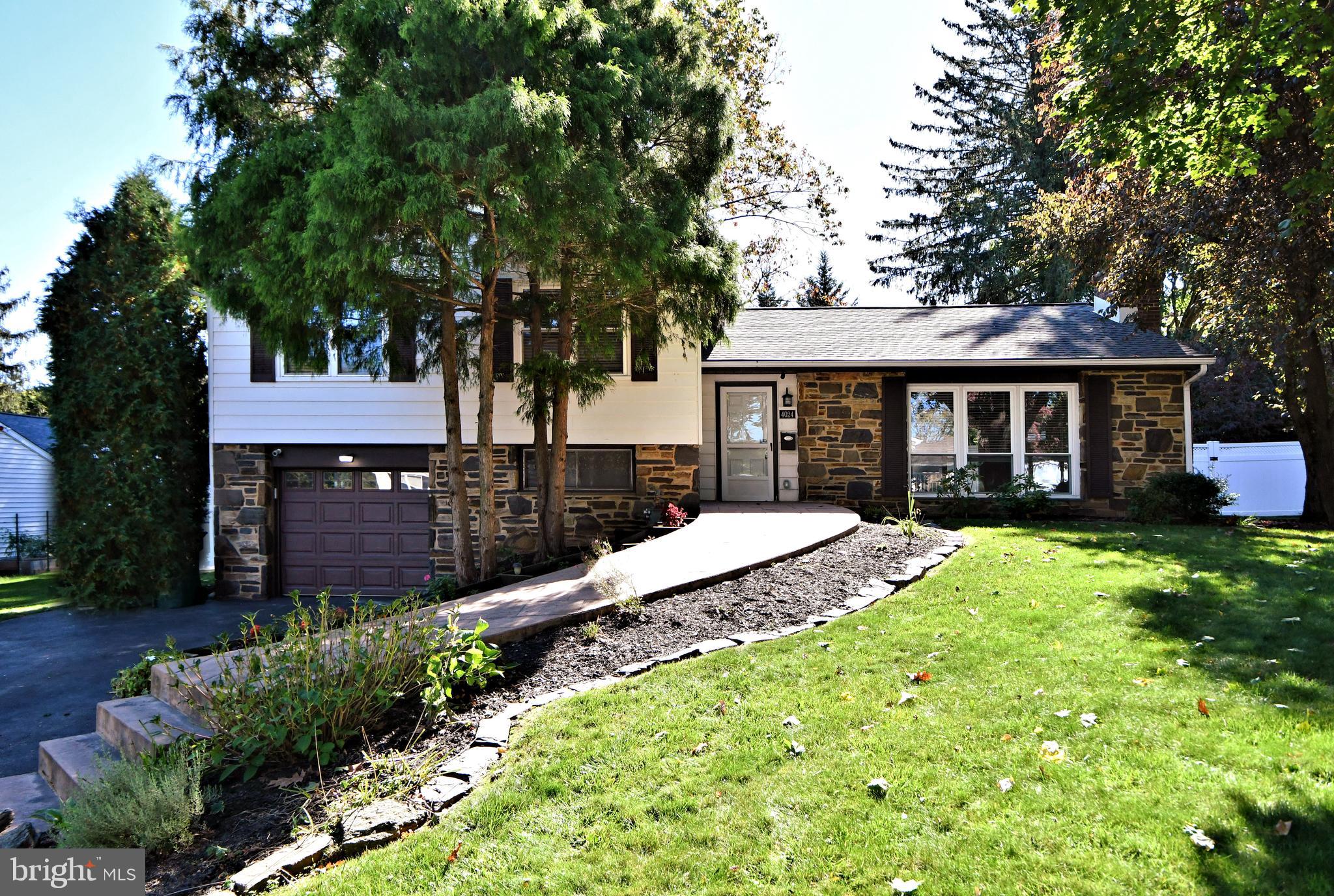 a view of a house with a yard and potted plants