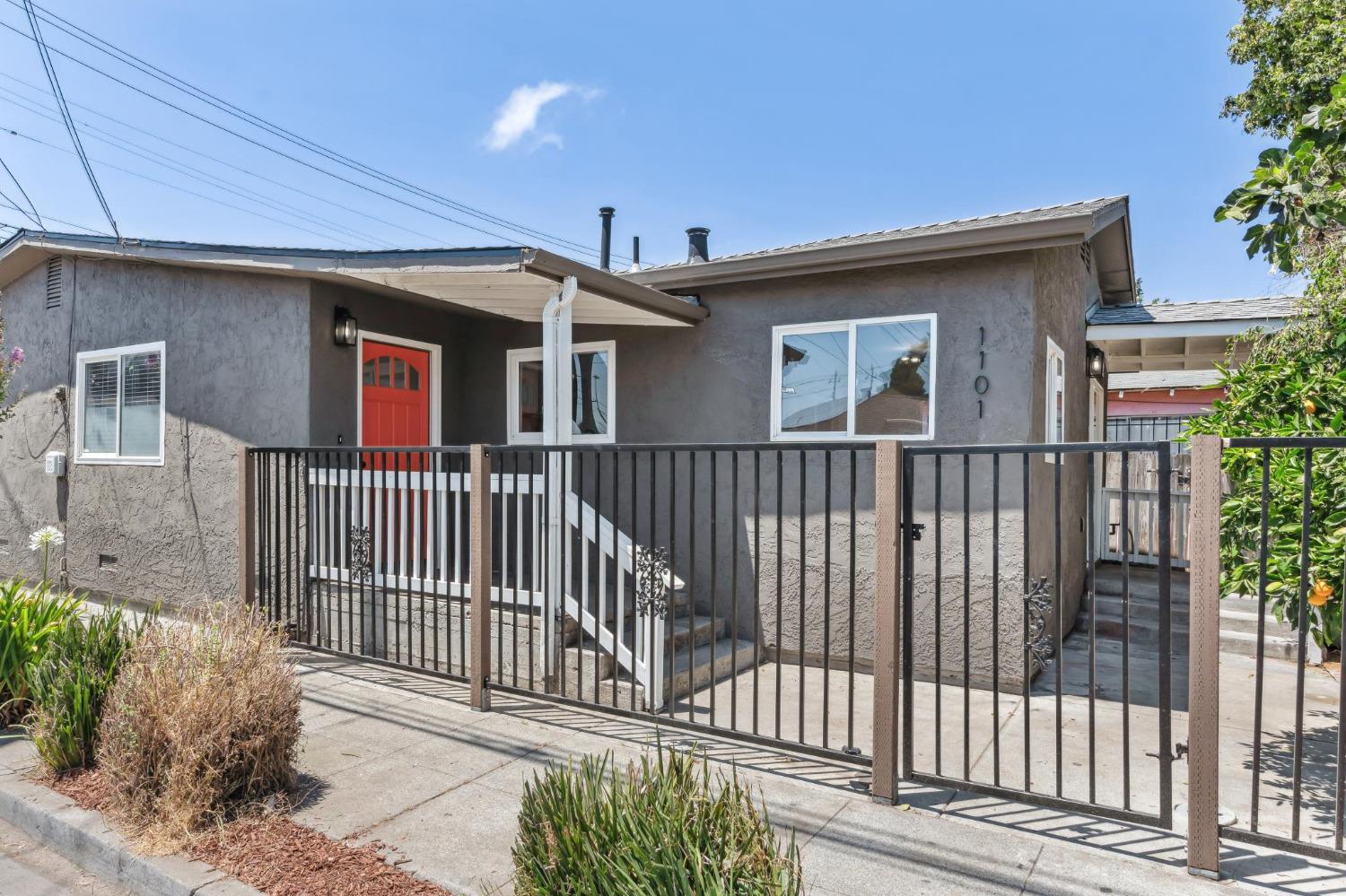 a view of a house with a small yard and wooden floor and fence