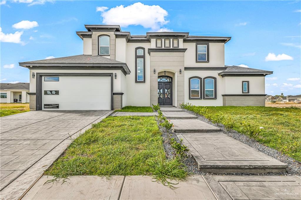 View of front of house with a front lawn and a garage