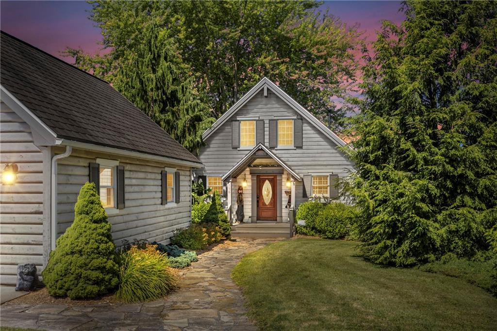 a front view of a house with a yard and potted plants