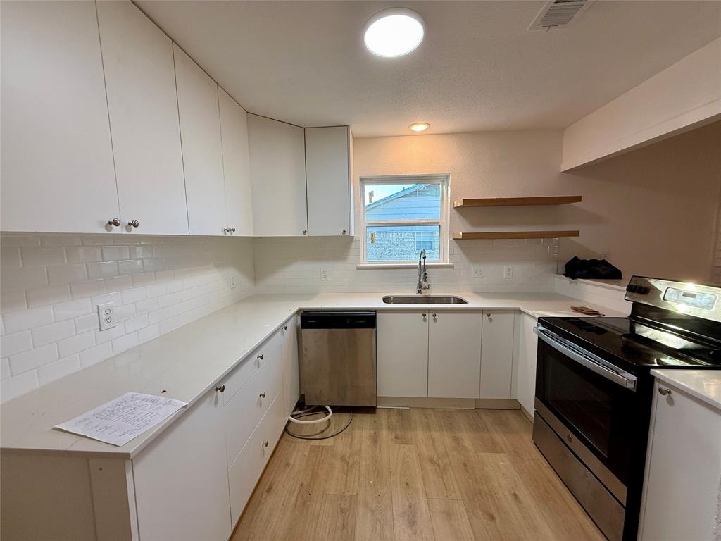 a kitchen with a sink stove and cabinets