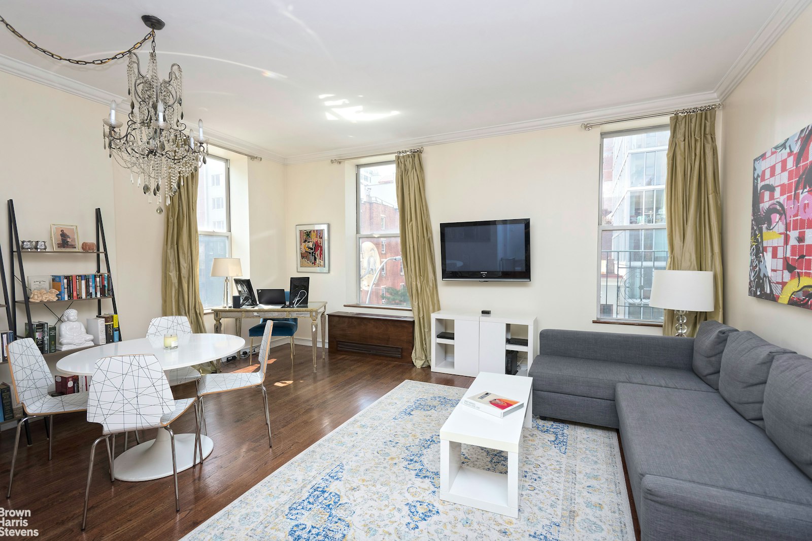 a living room with furniture a chandelier and a flat screen tv