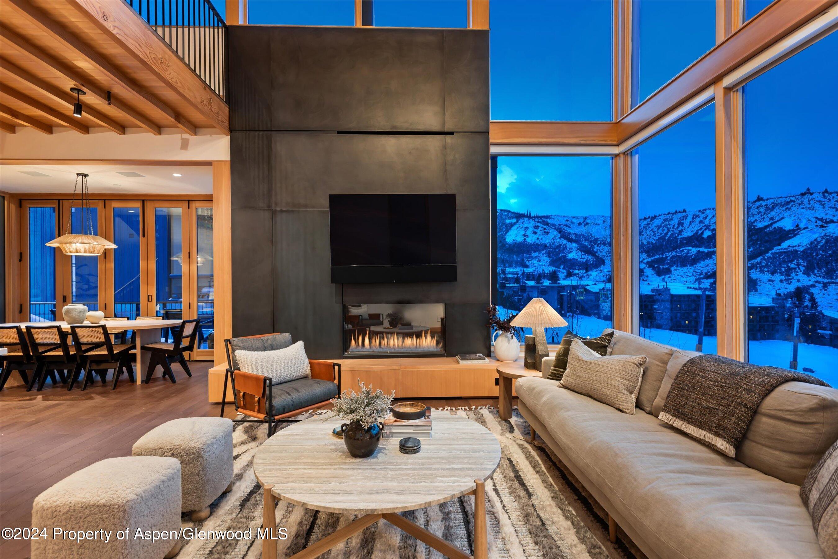 a living room with furniture a fireplace and a dining table