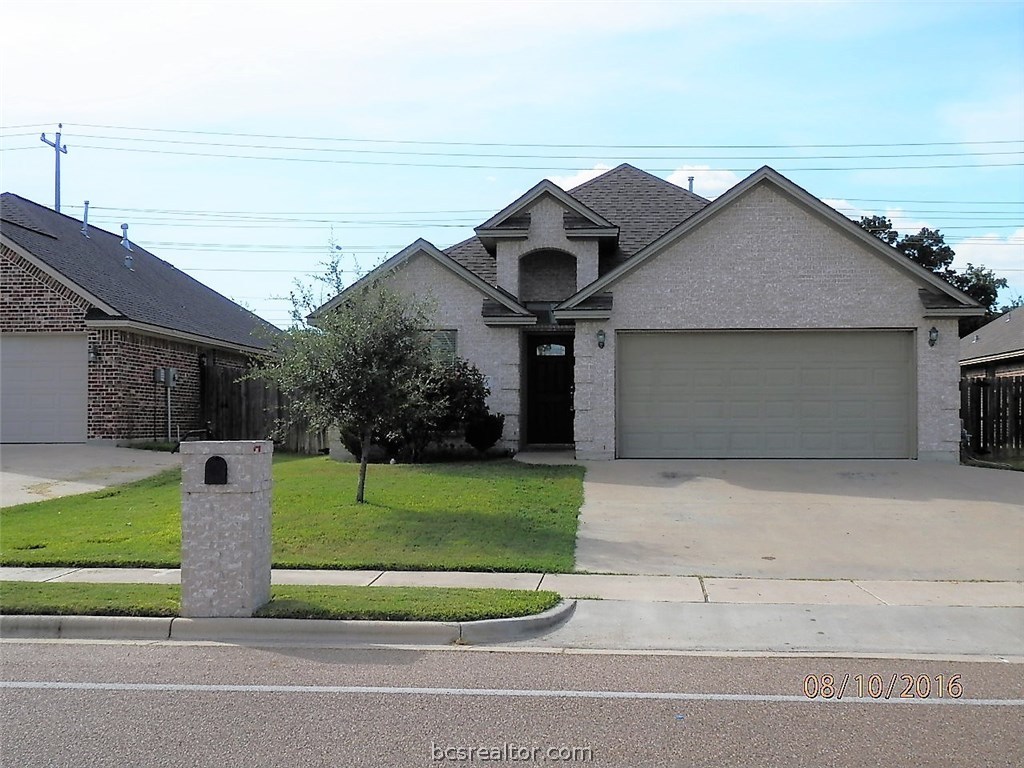 a view of a house with a yard and large parking space