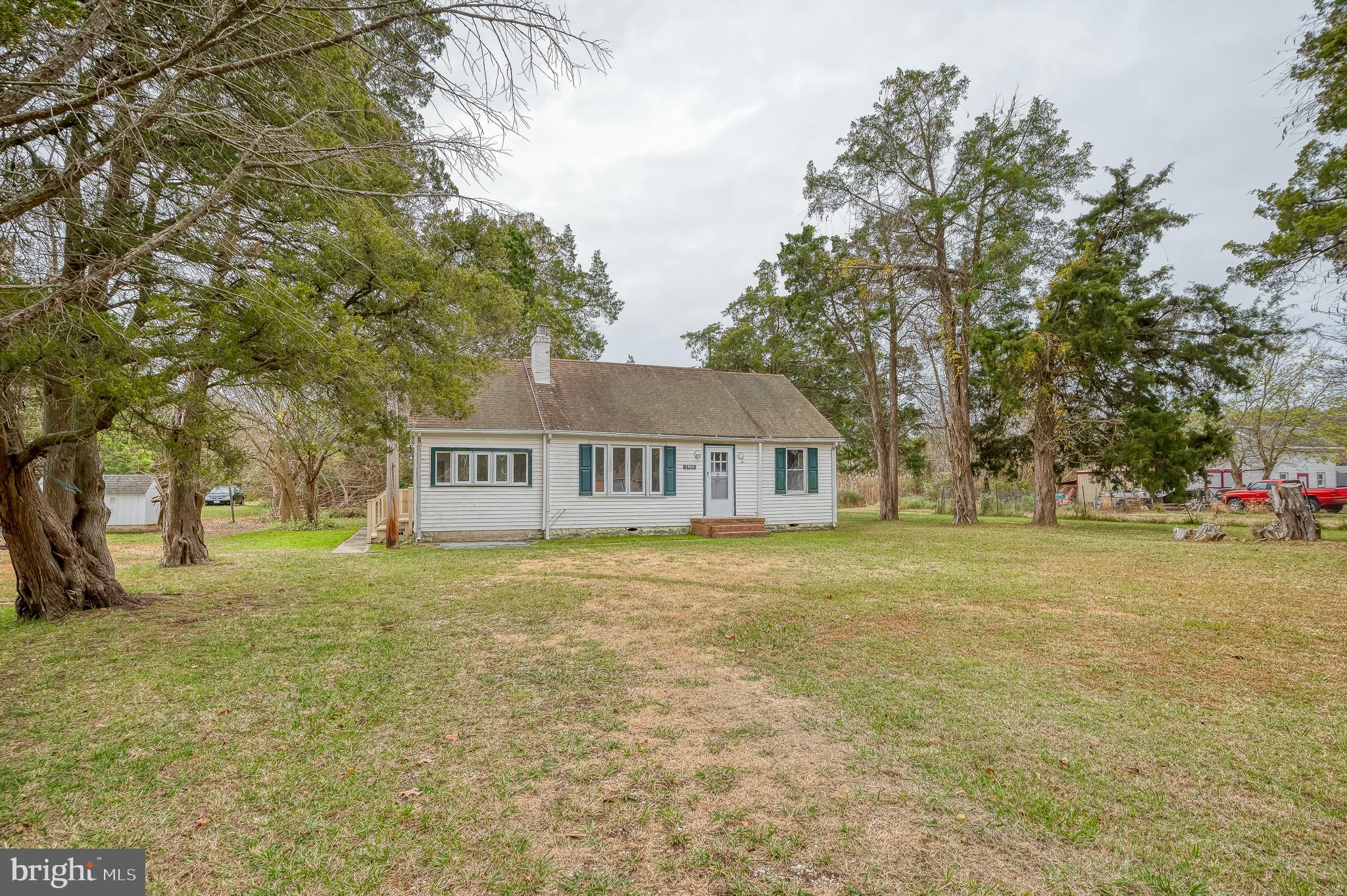 a view of a house with a big yard and large trees