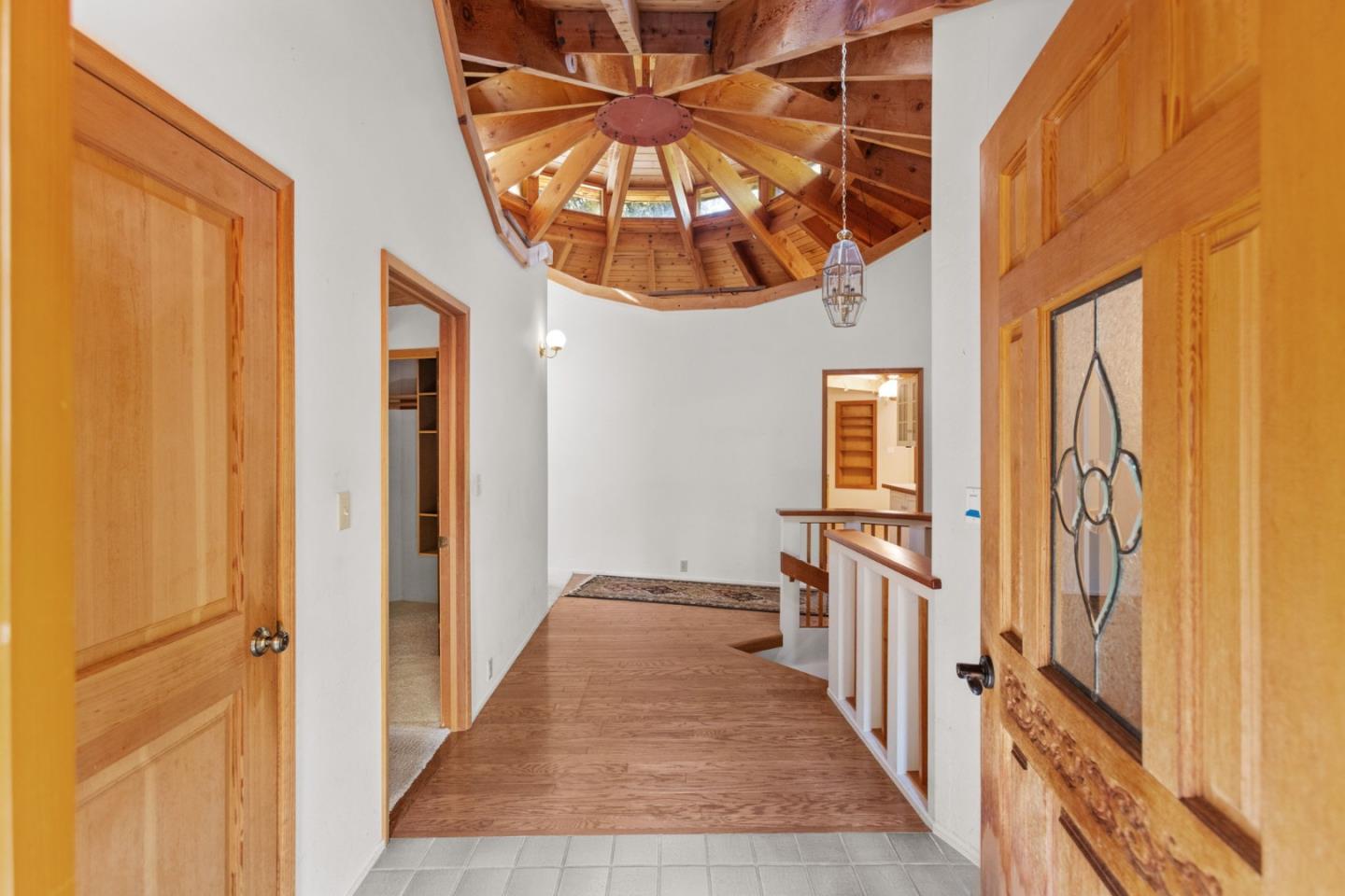 a view of a hallway with wooden floor and entryway