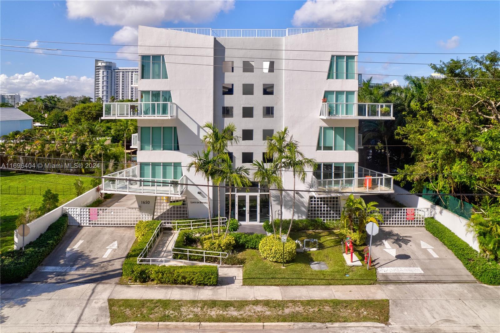 a front view of a multi story residential apartment building with a yard