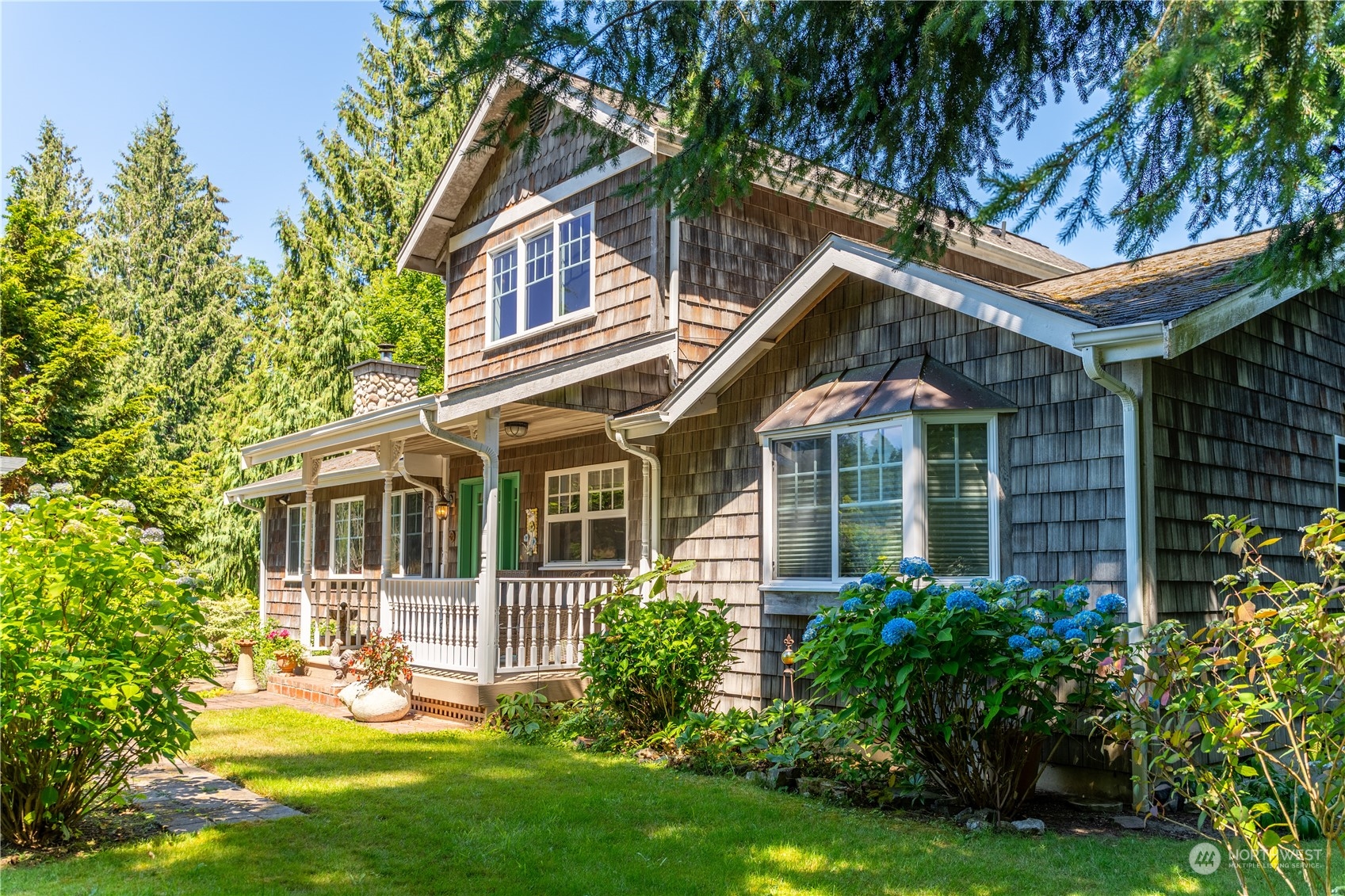 a front view of a house with a yard and potted plants