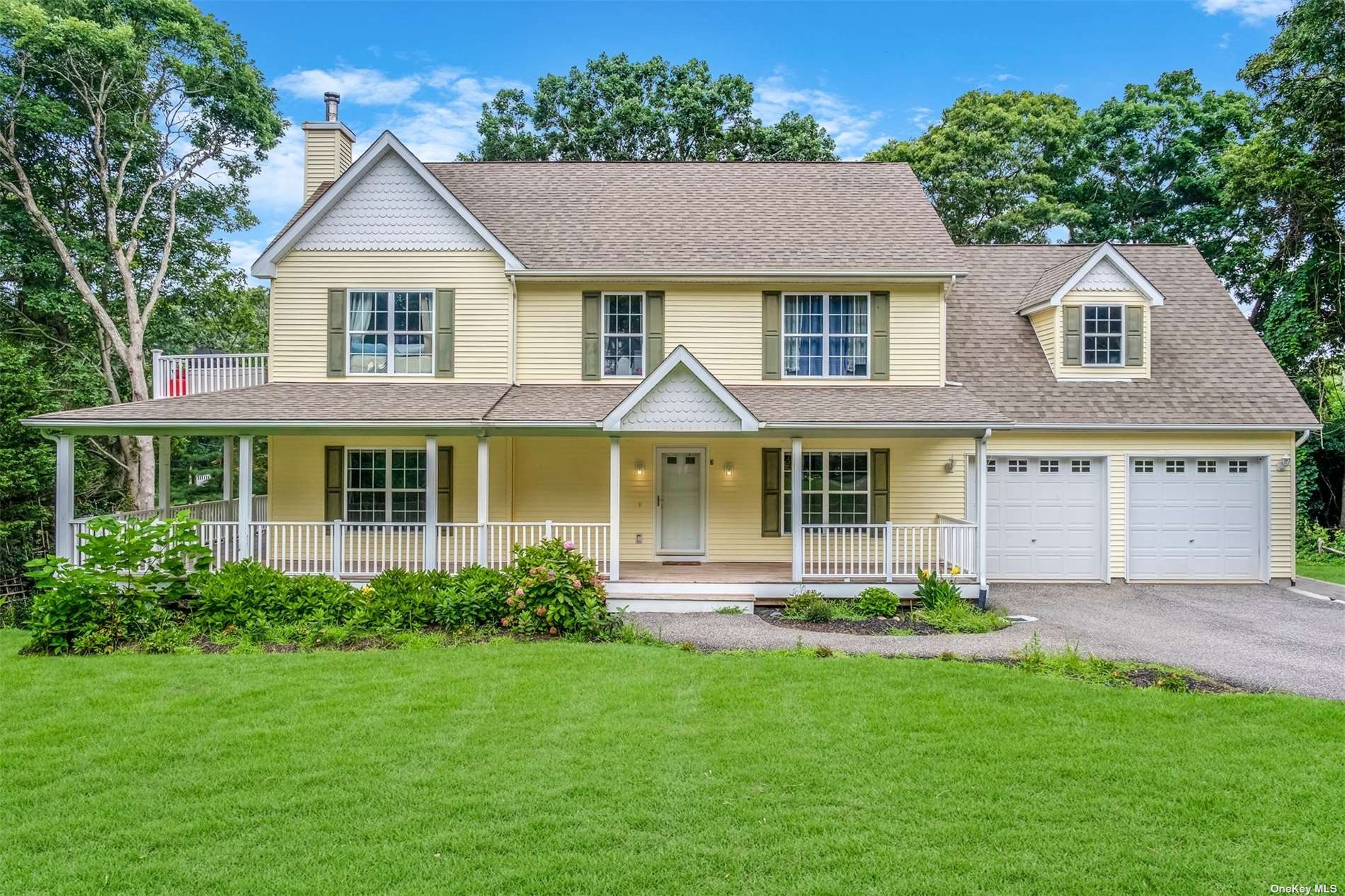 a front view of a house with a yard and potted plants