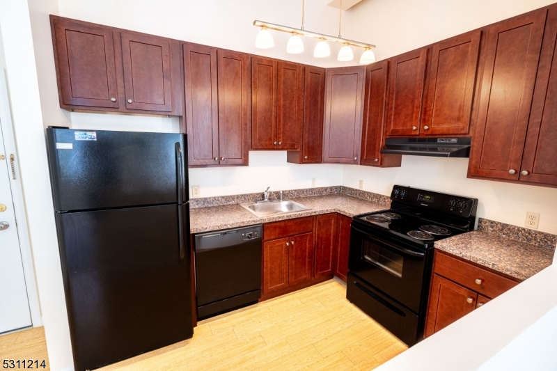 a kitchen with granite countertop wooden cabinets and stainless steel appliances