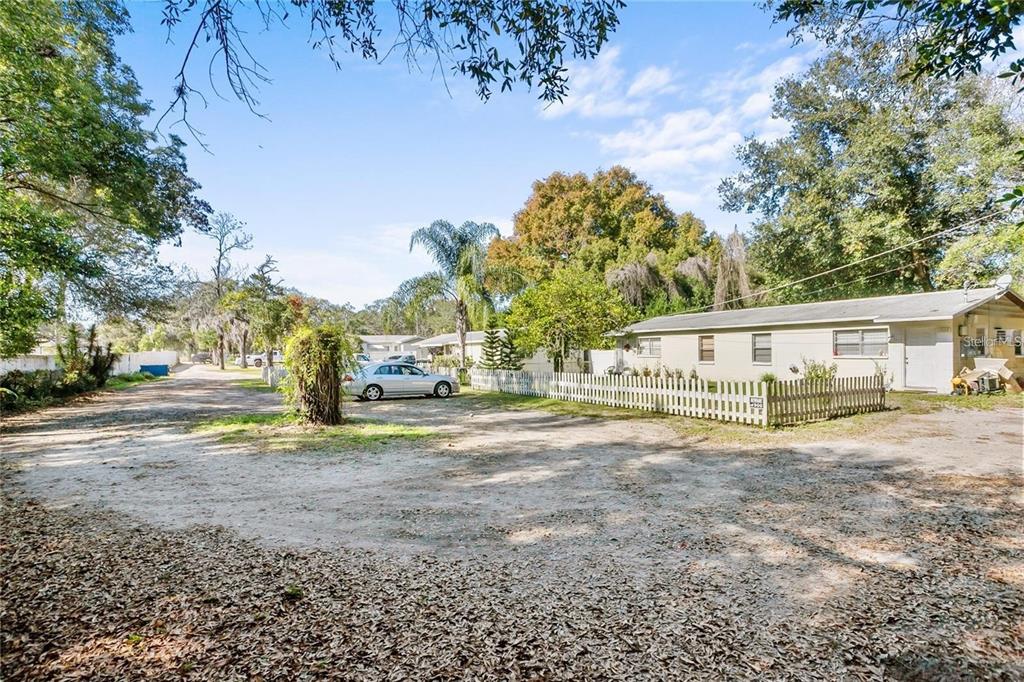 a view of a house with a big yard and large trees