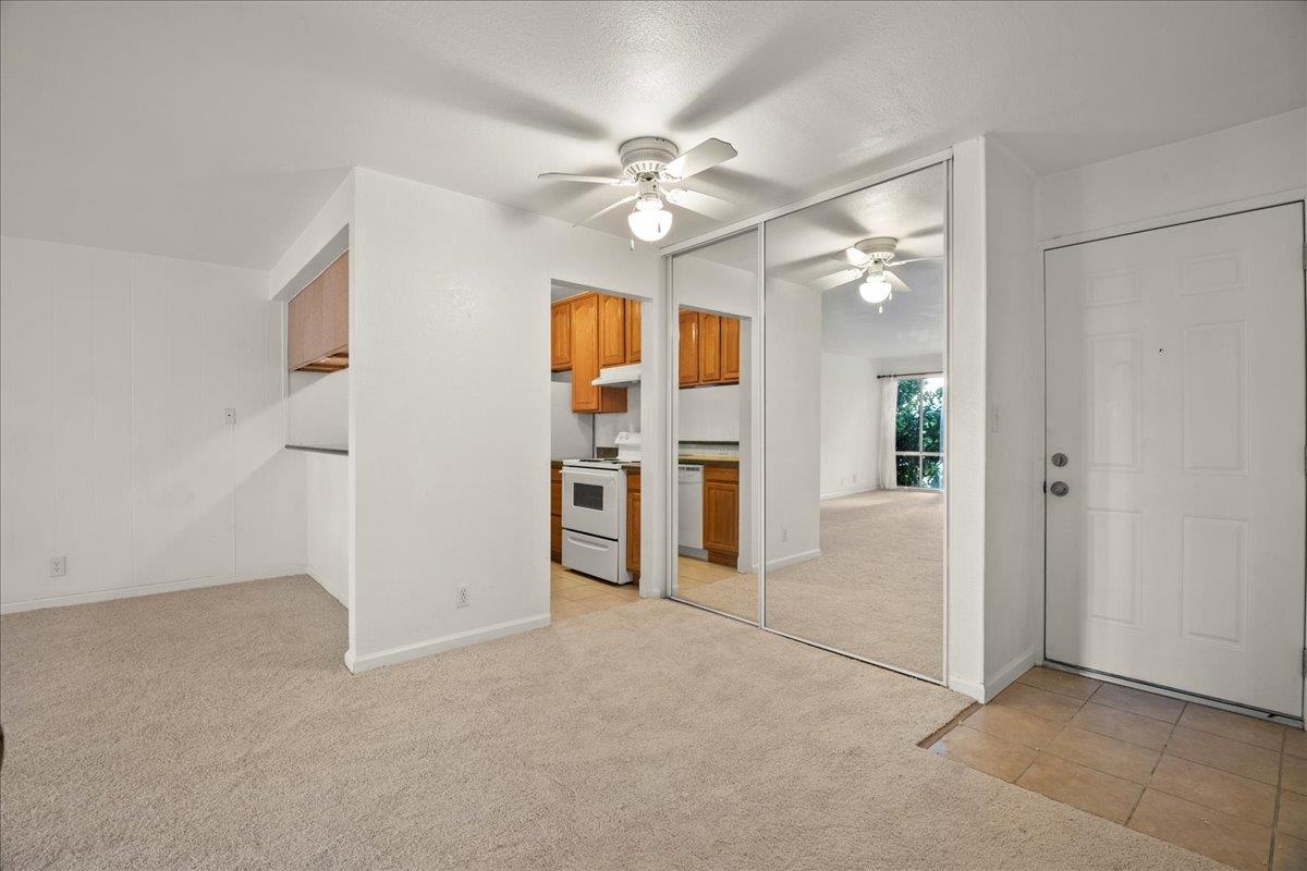 an empty room with closet and a ceiling fan