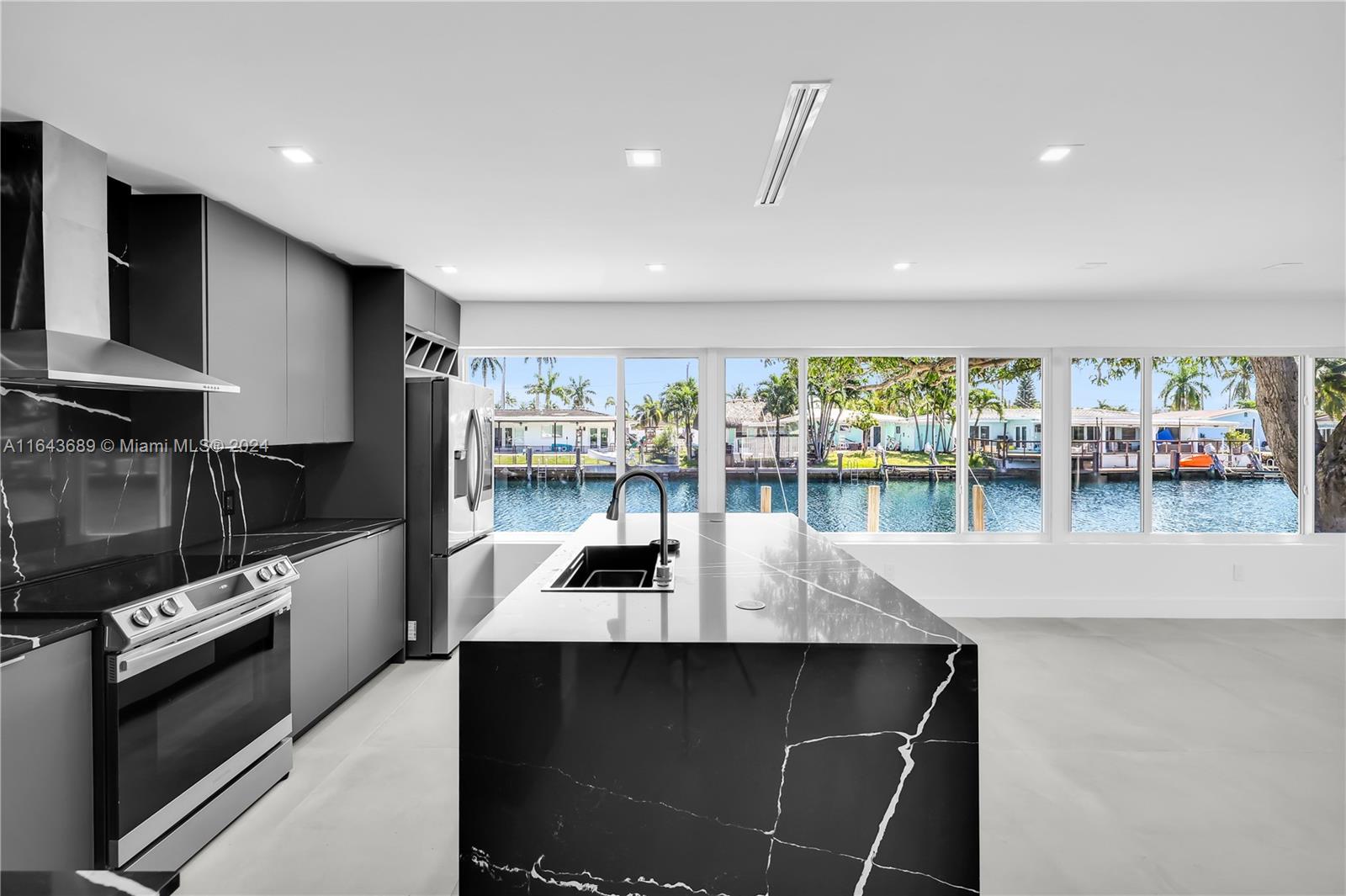 a kitchen with a large counter top stainless steel appliances and cabinets