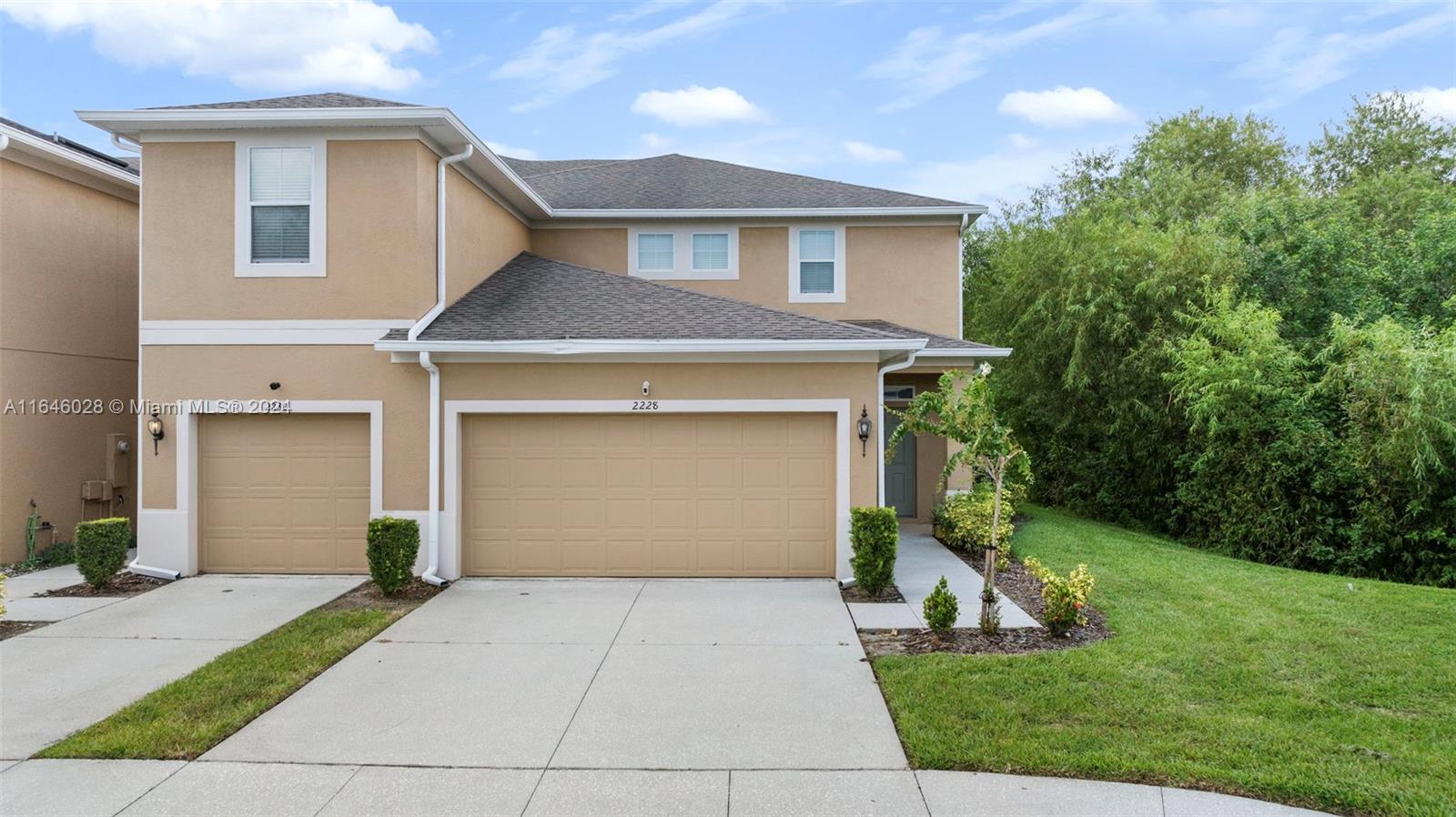 a front view of a house with a yard and garage