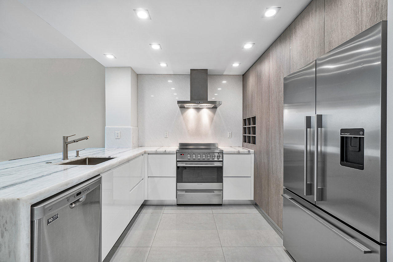 a kitchen with stainless steel appliances granite countertop a refrigerator and a sink