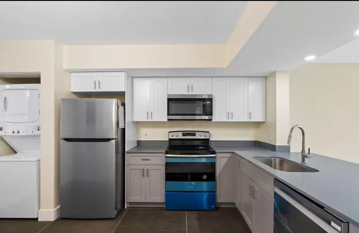 a kitchen with a refrigerator sink and white cabinets